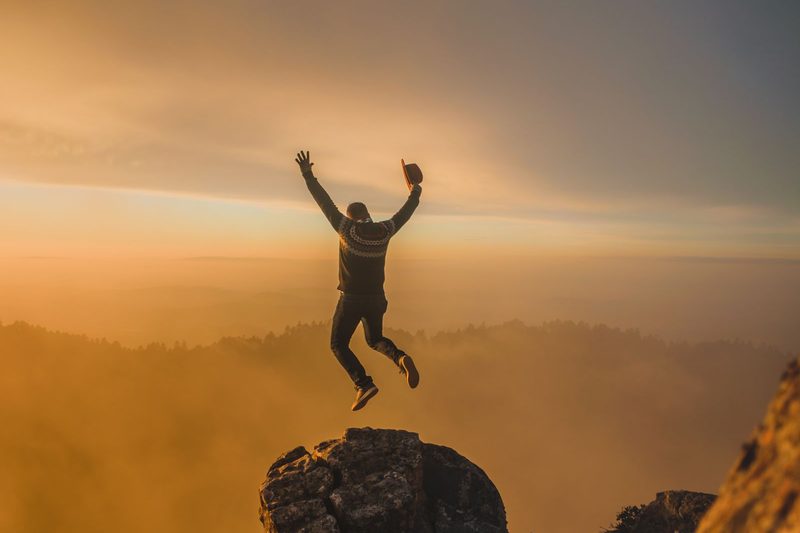 Joven saltando de alegría al amanecer
