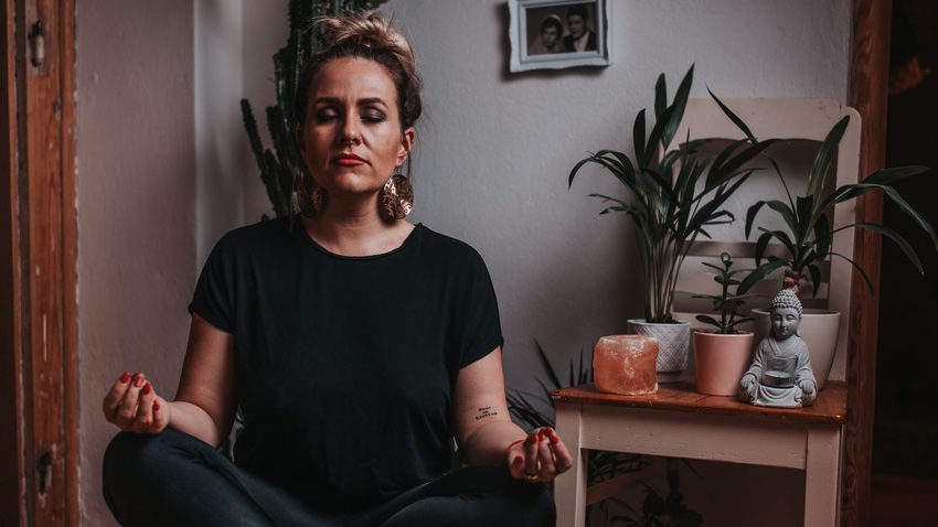 Mujer meditando relajada con los ojos cerrados